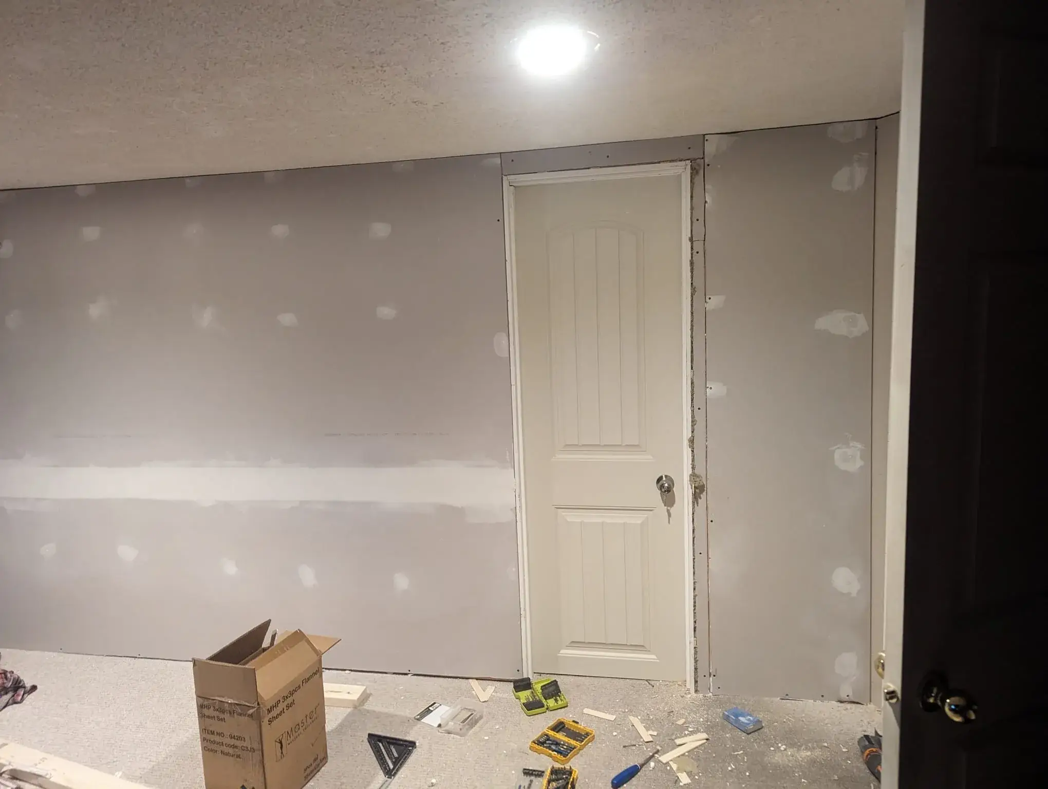 Freshly installed interior drywall and door frame during a handyman job in Calgary